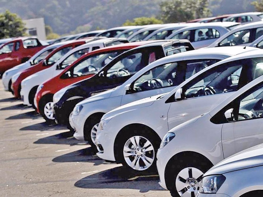 Fileira de carros brancos e vermelhos estacionados em pátio ao ar livre