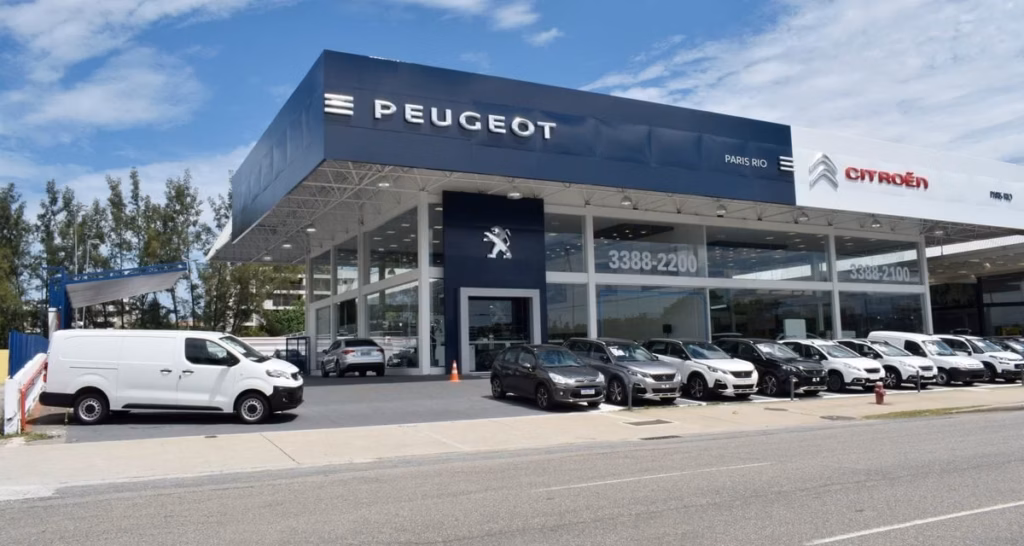 Fachada de concessionária Peugeot e Citroën com carros estacionados na frente