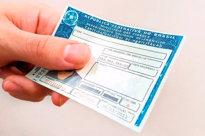 Mão segurando um documento de trânsito da República Federativa do Brasil