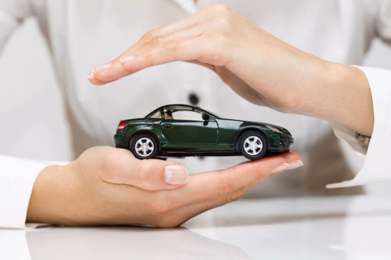 Mãos protegendo um carrinho verde em miniatura, uma por baixo e outra por cima
