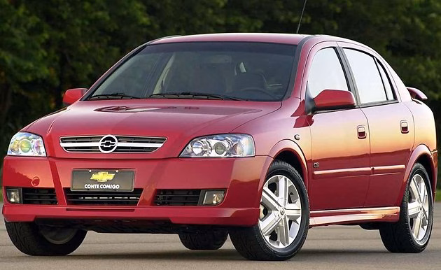 Sedã vermelho da Chevrolet visto de frente, estacionado ao ar livre