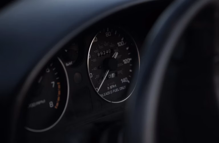 Painel de instrumentos de carro com velocímetro e conta giros em ambiente escuro