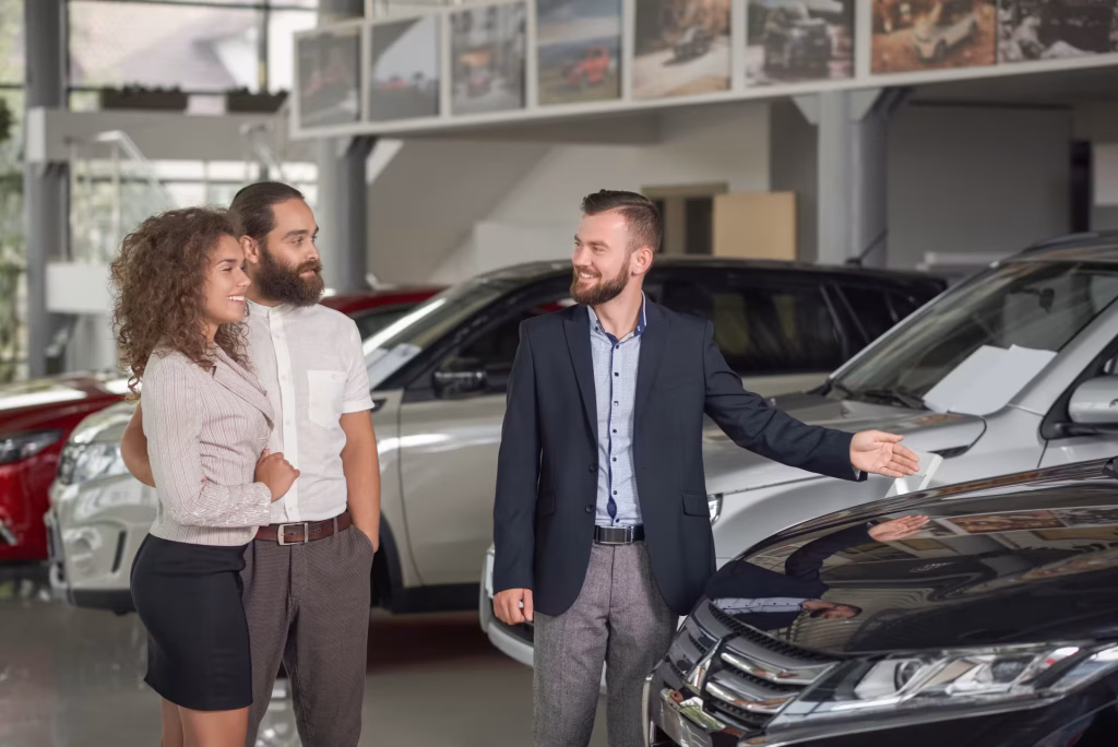 Vendedor apresentando um SUV para um casal no showroom